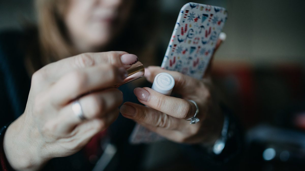 Mobilní telefon se zprávou na kuchyňském stole vedle hrnku čaje