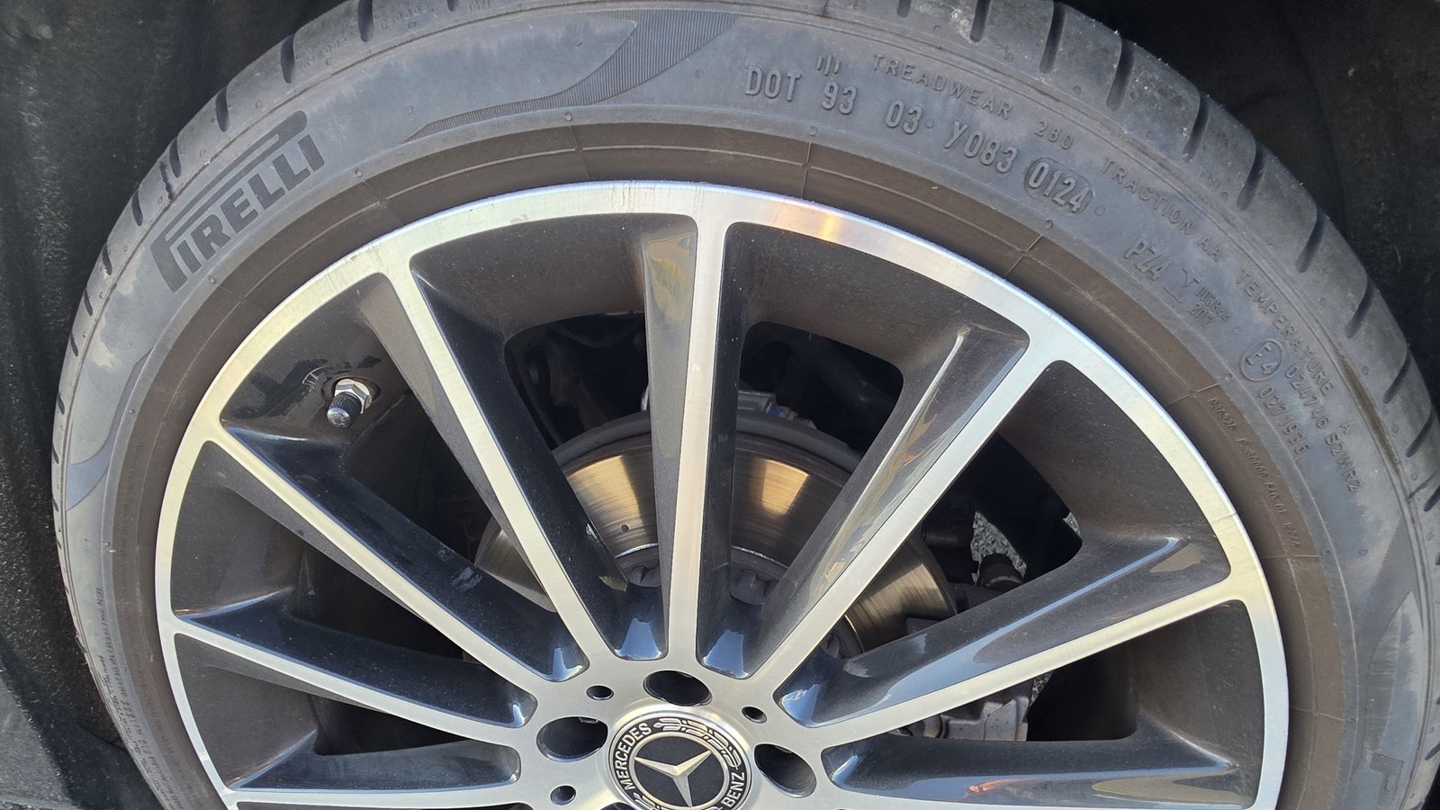 Horní část kola osobního auta s litým diskem, na boku pneumatiky je vidět kód DOT 93 03 Y083 0124 a údaje Treadwear a Traction