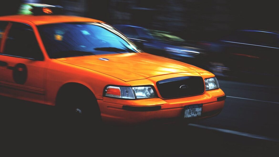 Žluté taxi projíždí městskou ulicí
