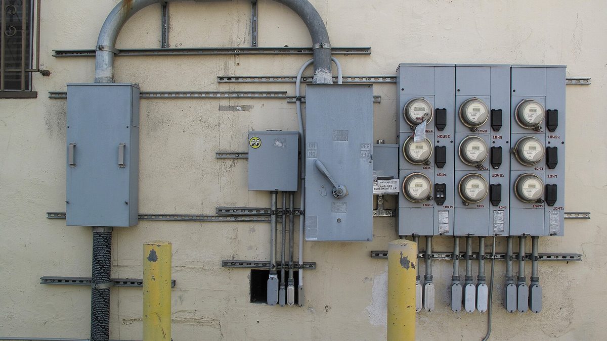 Elektroměry v kovové skříni u plotu rodinného domu