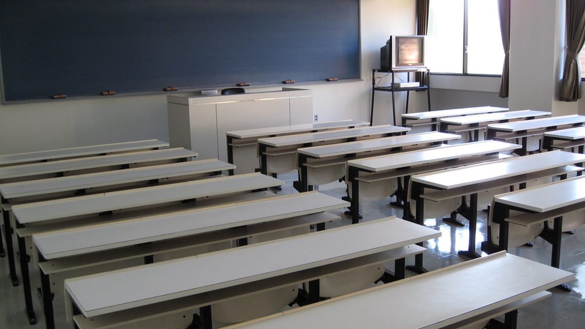 Prázdná školní třída s lavicemi a tabulí