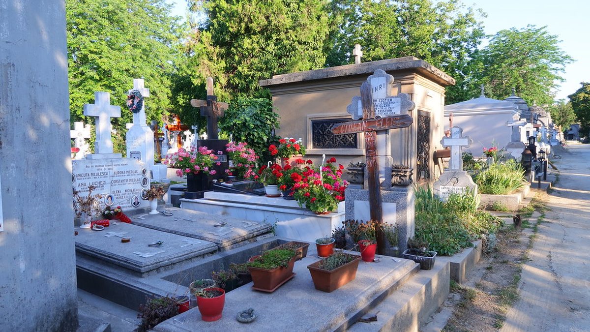 Hroby s kříži a květinami na hřbitově