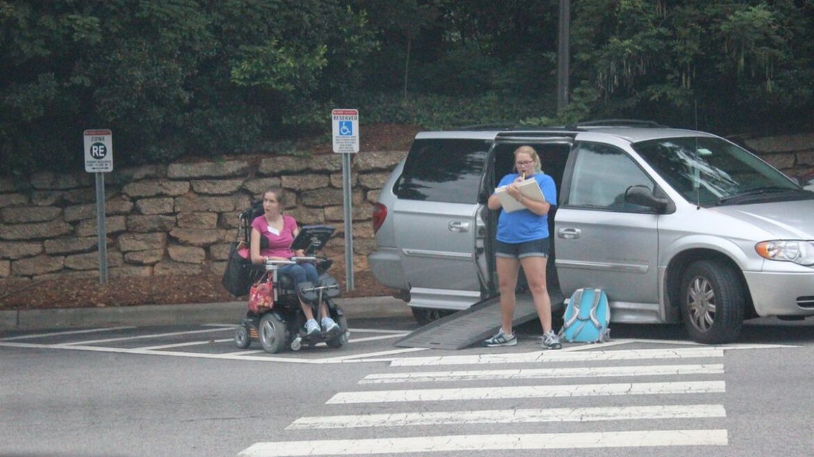 Žena na vozíku u auta s nájezdovou rampou