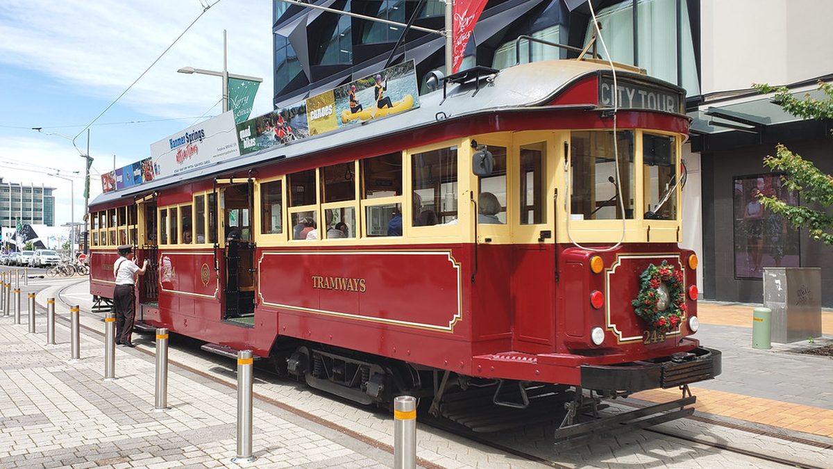 Červená tramvaj projíždí městskou ulicí
