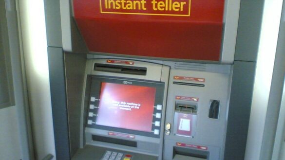 Lidé čekají ve frontě u bankomatu